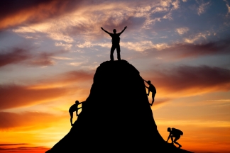 Man on top of the mountain and the other people to climb up